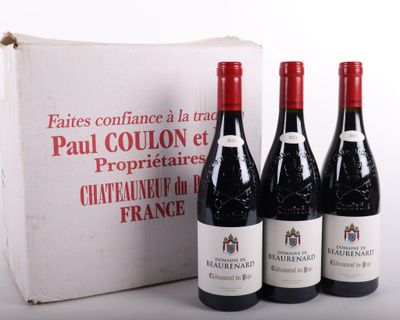 trois bouteilles de vin rouge sont posées devant une boîte blanche