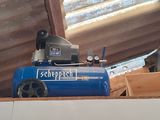 a blue air compressor sitting on top of a wooden box