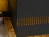 an image of a black and gold clock on a wooden base