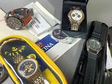 several watches are sitting on a table next to a watch case