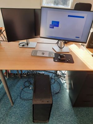 un bureau sur lequel sont posés deux écrans et un ordinateur portable