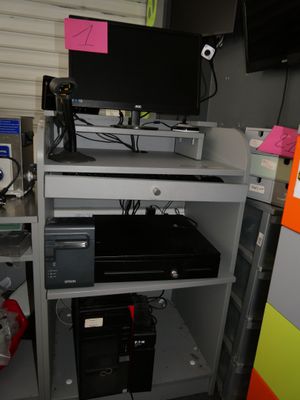 a computer desk with a monitor and a printer on top of it