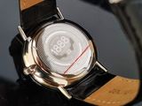 a close up of a watch on a black surface