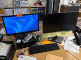 un bureau sur lequel se trouvent un ordinateur, une imprimante, un téléphone et d'autres objets