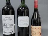 trois bouteilles de vin sont alignées sur une surface grise