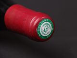 a close up of a red wine bottle with a green label