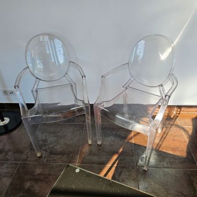 deux chaises transparentes posées l'une à côté de l'autre sur le sol