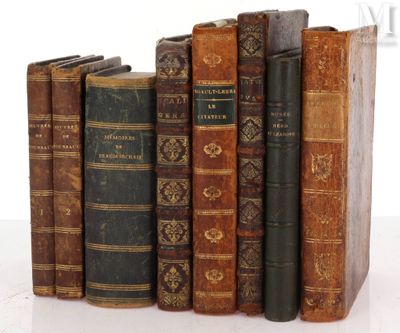 several old books are lined up in a row on a white surface