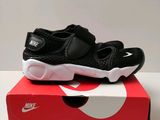 une paire de chaussures noires et blanches posée sur une boîte rouge