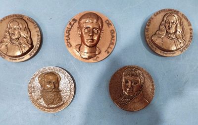 four different types of bronze coins on a blue surface