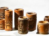 five wooden vases with carvings on them on a table
