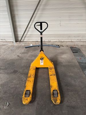 un chariot élévateur jaune garé dans un garage, à côté d'une porte de garage