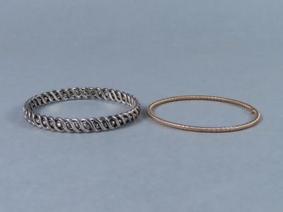 deux bracelets en argent et une bague en or sur fond bleu