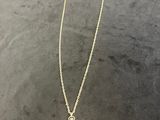 a gold necklace with a white stone pendant on it