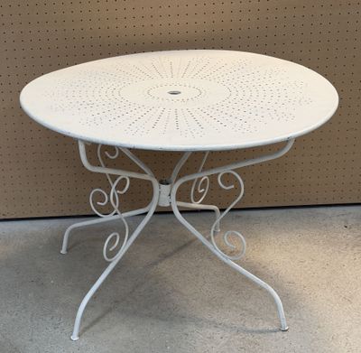 une table blanche au plateau circulaire posée à même le sol