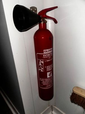 un extincteur rouge dans un coin de la pièce