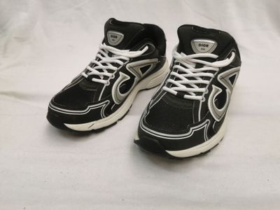 une paire de baskets noires et blanches avec des lacets blancs sur fond blanc