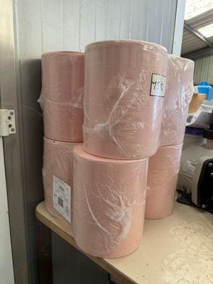 plusieurs rouleaux de papier de soie rose posés sur une étagère dans une pièce