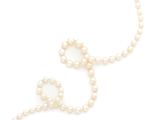 a close up of a pearl necklace on a white background