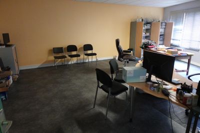 une pièce équipée d'un bureau, de chaises et d'un écran d'ordinateur