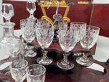 bottles and glasses on a wooden tray with a mirror in the background