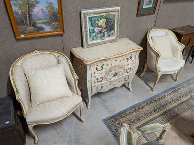 trois chaises et une table dans une pièce où sont accrochés des tableaux au mur