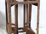 an old wooden stand with a metal structure on it