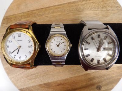 trois montres sont posées sur une surface en bois, avec un bracelet noir