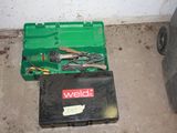 a green tool box with tools in it on the floor