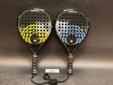 deux raquettes de tennis aux motifs différents, posées sur une surface grise