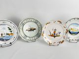 four plates with different designs on them sitting next to each other