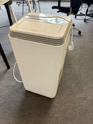 une glacière blanche posée par terre dans un bureau