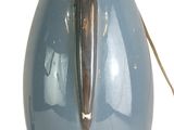 un vase bleu muni d'une poignée en métal sur fond blanc