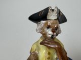a figurine of a man wearing a hat and holding a pipe