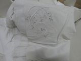 a white pillow with a monogram on it sitting on a table