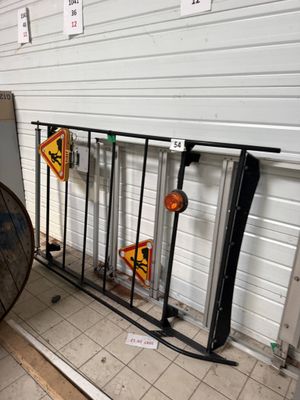 a large umbrella sitting on the ground next to a fence