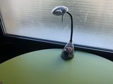 a small table with a lamp on it in front of a window
