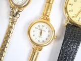 three watches sitting next to each other on a white surface