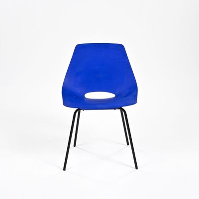une chaise en plastique bleue avec des pieds noirs et un trou dans l'assise