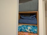 une photo d'un placard contenant des serviettes et des couvertures pliées