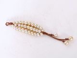 two strands of white pearls on a brown string