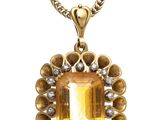 an image of a necklace with a yellow stone surrounded by diamonds