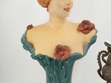 a statue of a woman and a vase of flowers on a table