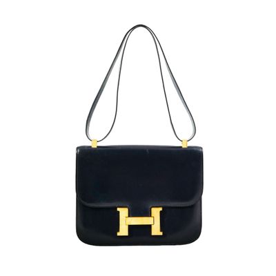 a black leather handbag with gold hardware on the handle