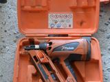 une mallette à outils orange contenant une agrafeuse, un pistolet à clous et d'autres outils