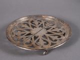 a silver plate with a design on it on a table