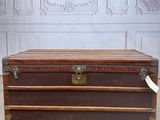 a brown trunk sitting on the floor in front of a wall