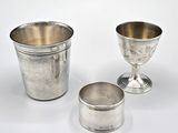 deux tasses en argent posées l'une à côté de l'autre sur une surface blanche
