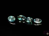 three blue topazte gems sitting on a black surface
