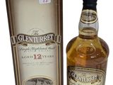 une image d'une bouteille de whisky à côté d'une boîte en carton
